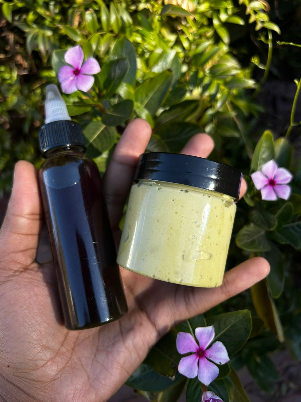 Actual WM&R Naturals hair oil and cream held outdoors